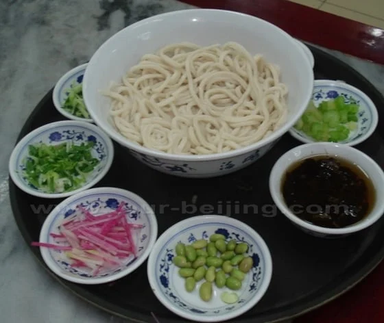 Zhajiangmian noodles served with bean-and-meat sauce and separate vegetable garnishes